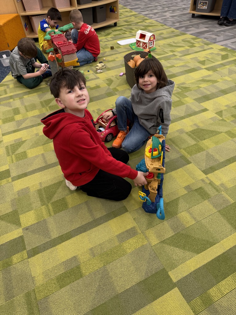 Students on floor playing with toys