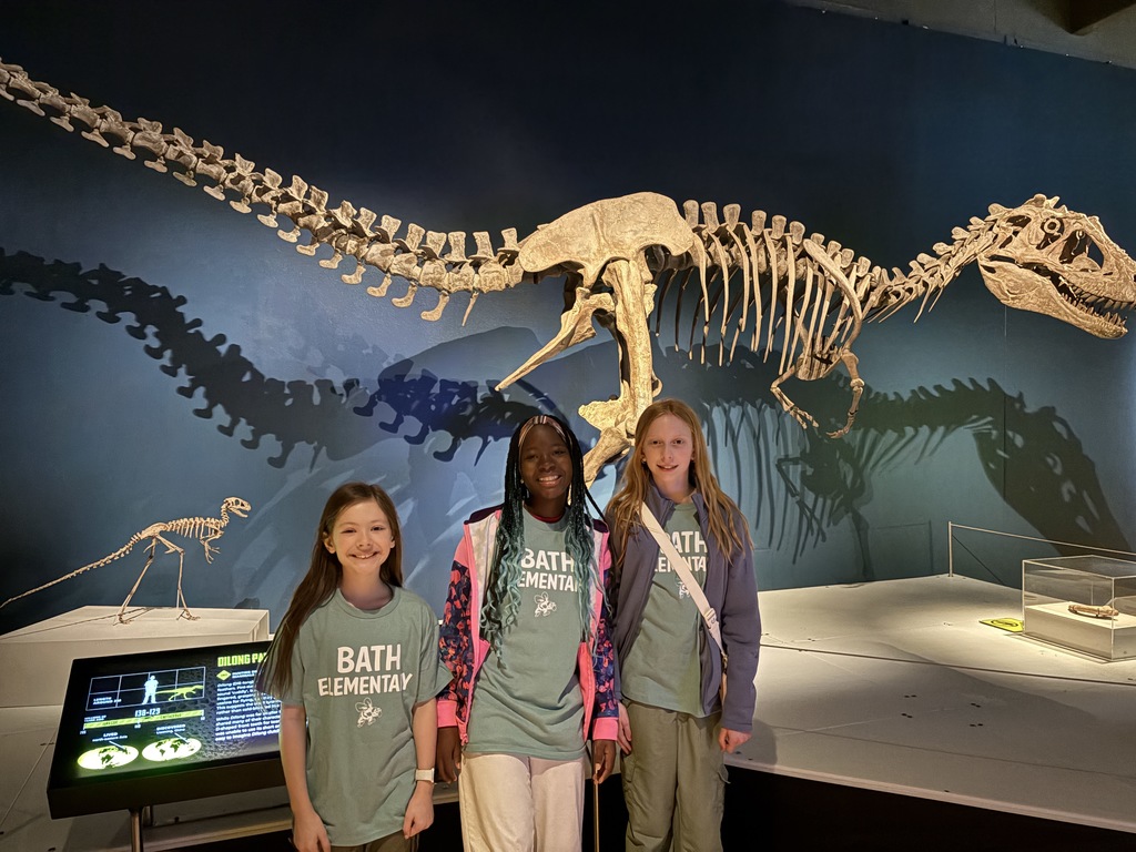 Girls in front of a dinosaur skeleton
