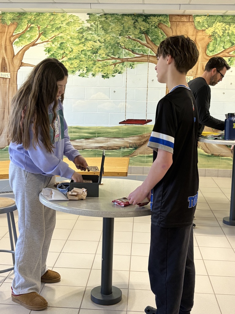 Boy and girl standing at a  table 