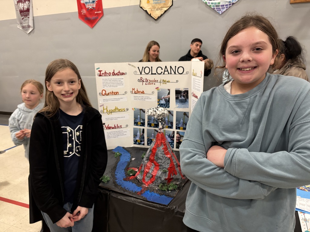 Girls standing next to science project display