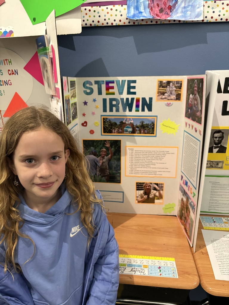 Girl standing next to display board biography project
