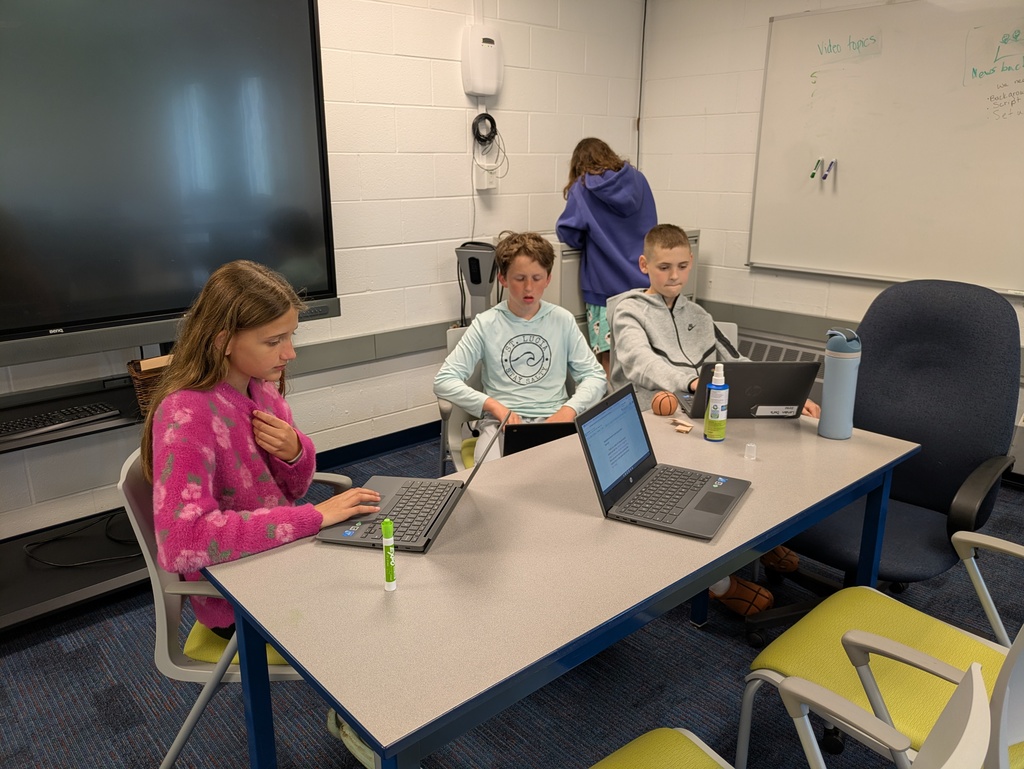 Students sitting at table using their chromebooks