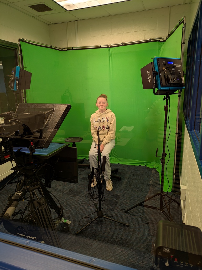 Girl sitting on a stool in front of the green screen