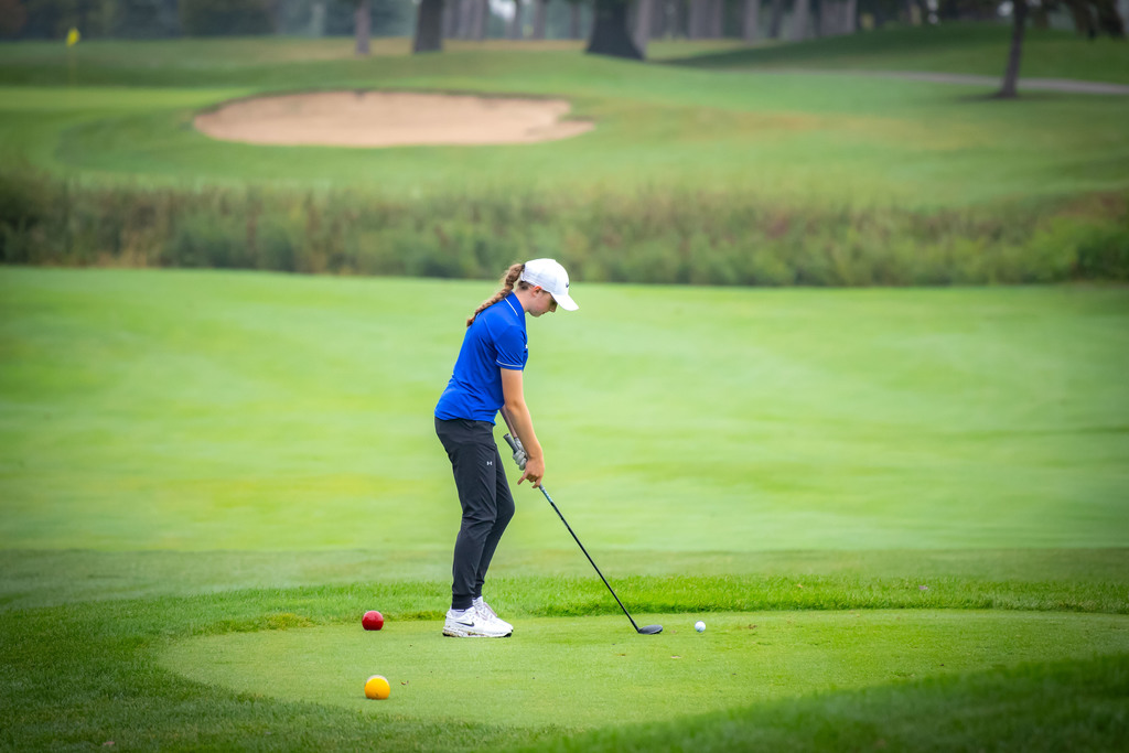 Girls golf player standing on the tee