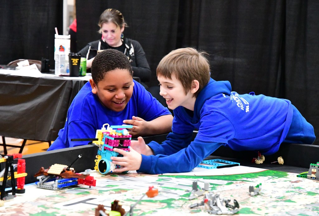 Boys smiling looking at robot