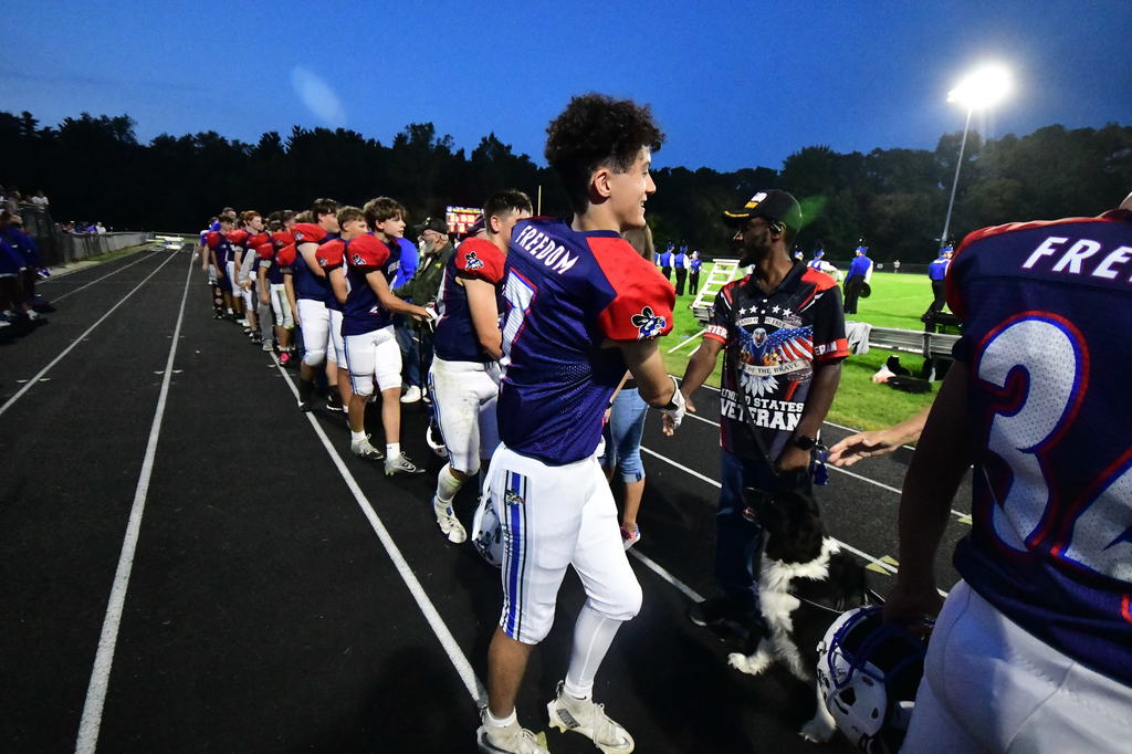 Football players shaking hands of Veterans