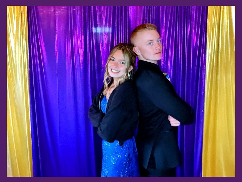 Boy and girl standing back to back in photo booth