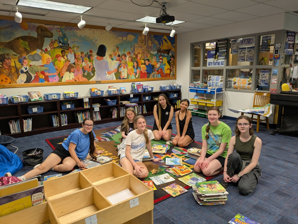 Girls sitting on the floor sorting library books