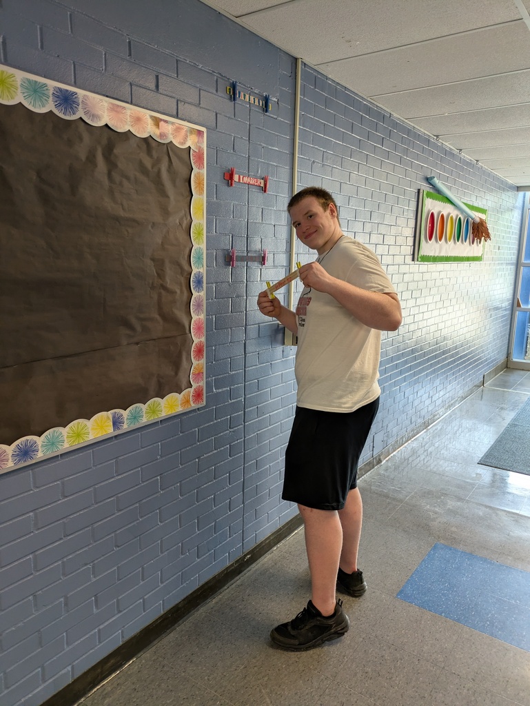 Student removing hangers from the wall