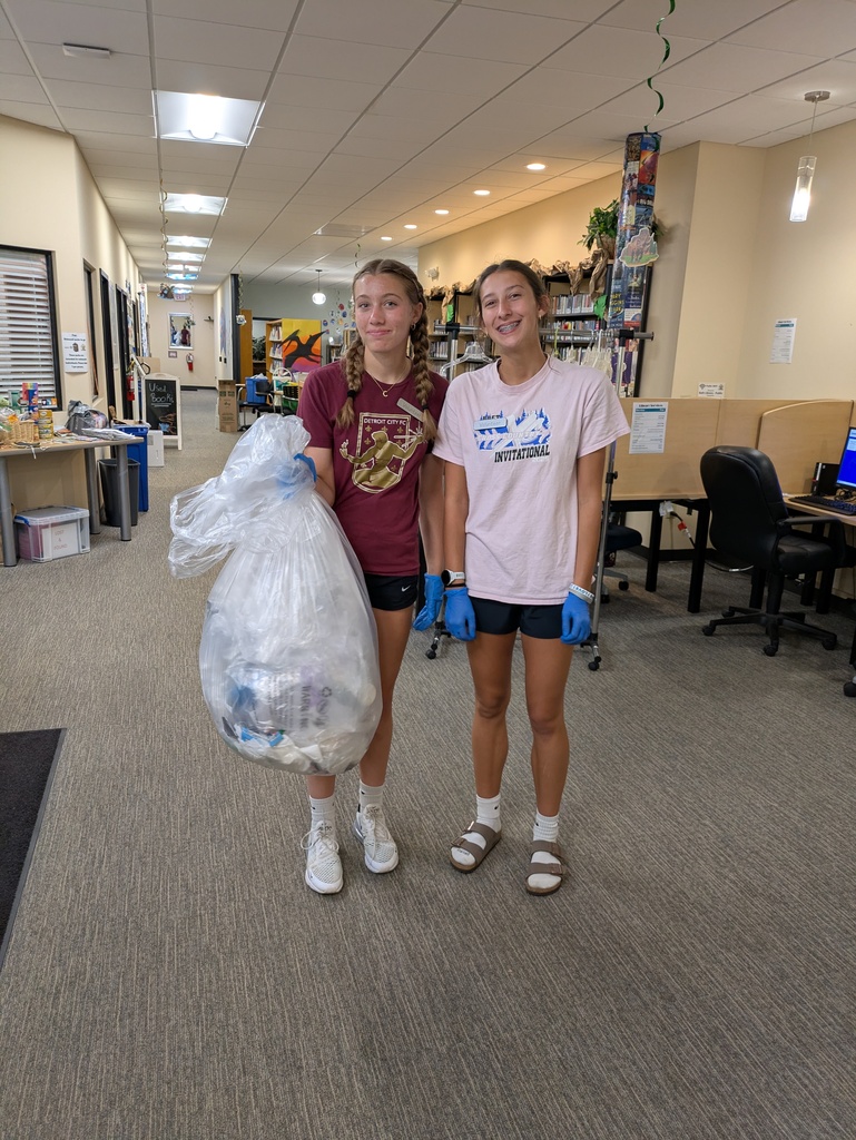 Girls picking up trash at the library