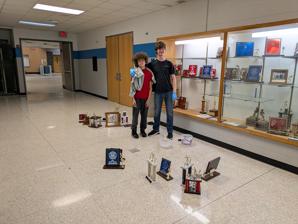 Boys standing in front of trophy case