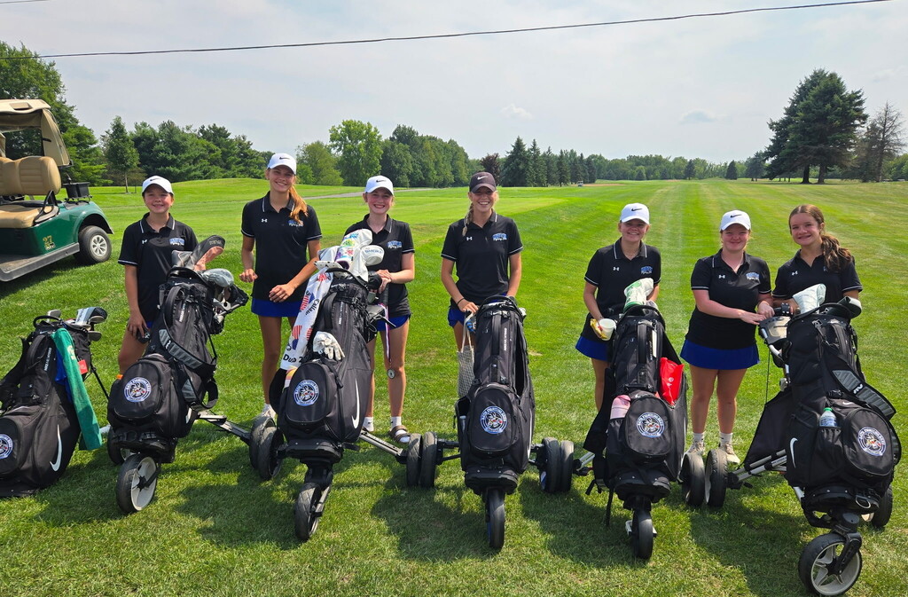 Girls standing with their golf clubs