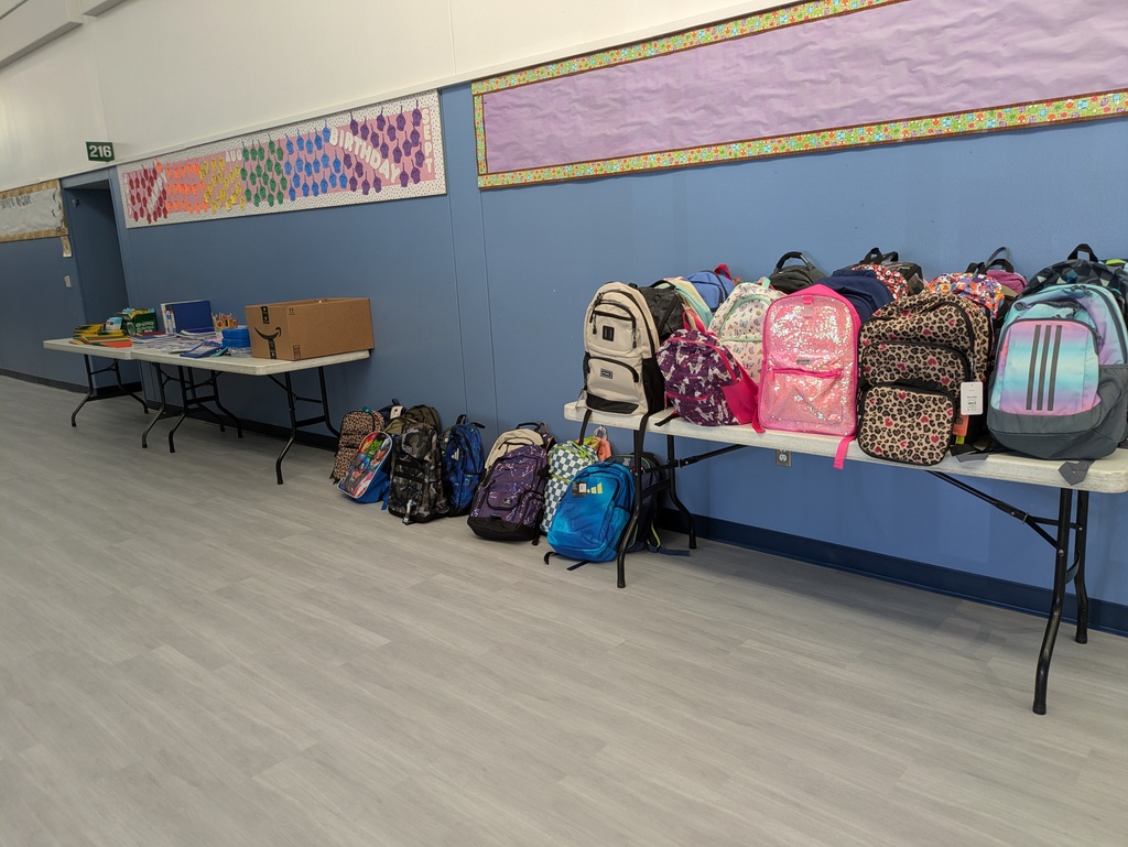 Tables with school supplies and backpacks