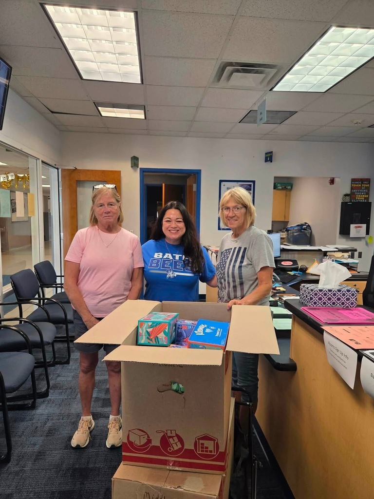 Mrs. Lacey and Auxiliary ladies standing next to boxes of school supplies