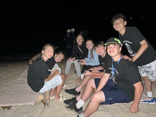 Students at a beach bonfire.