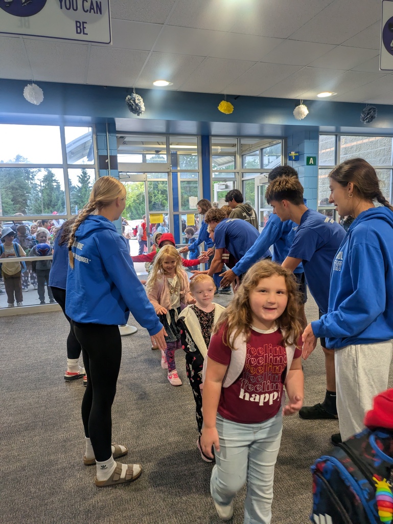 Students walking in next to the team