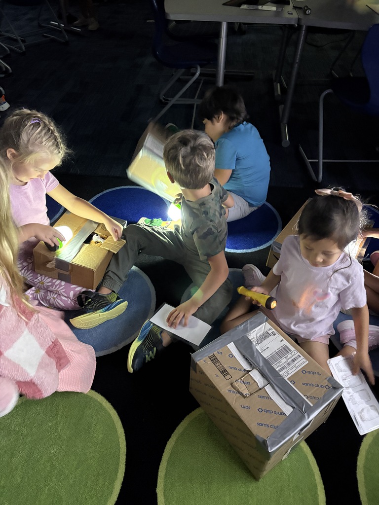 Students with flashlights and boxes