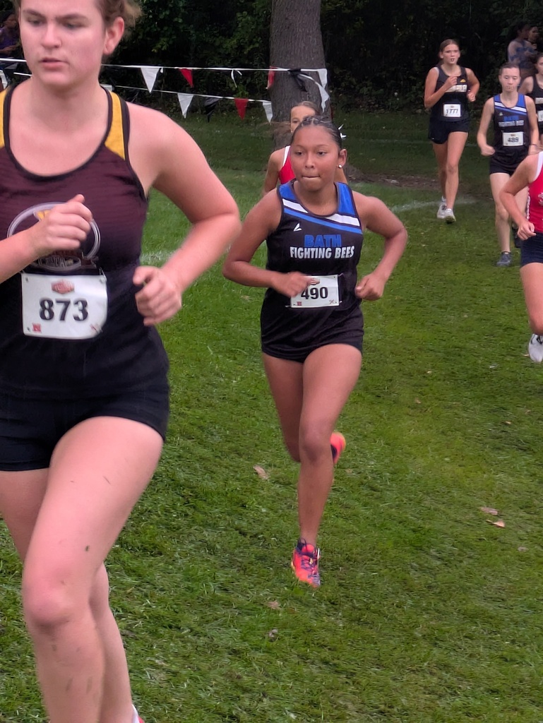 Girl from Bath Cross Country team running on the grass