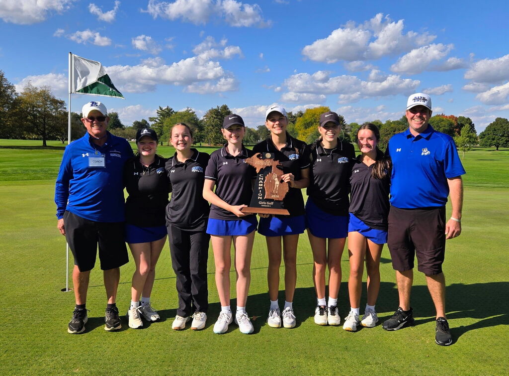 Girls Team with coaches posing for a picture on the putting green