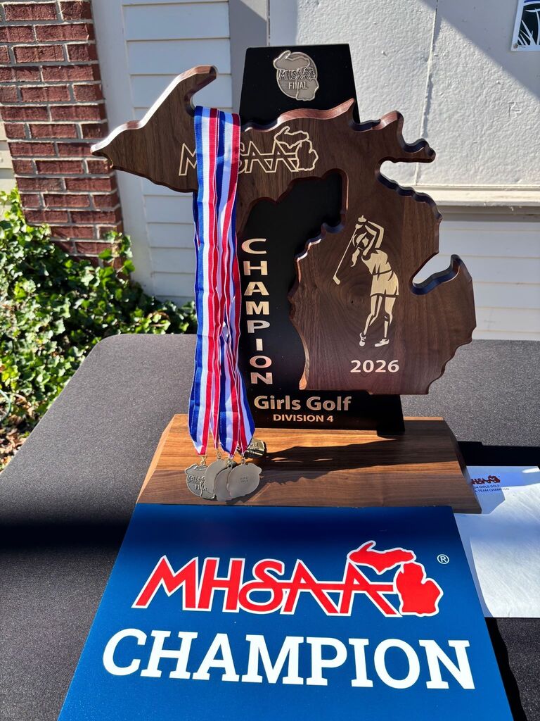 MHSAA championship trophy with red white and blue ribbon medals hanging from it