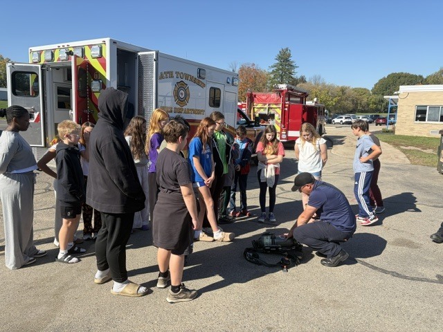 Students watching a demonstration in front of a Bath Township Fire Truck