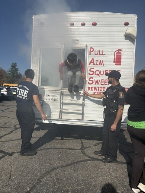 Back of trailer with smoke coming out of it from DeWitt Township Fire/Rescue - child climbing out of back of trailer