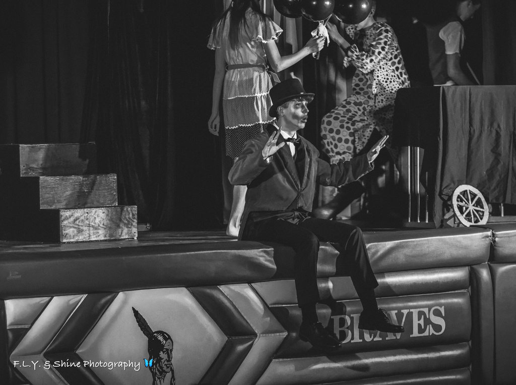 Actor sitting at edge of stage