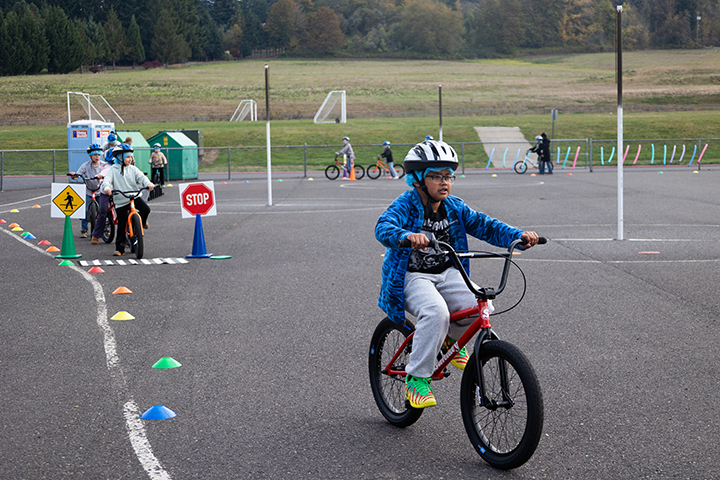 a student rides his bike while wearing a helmet