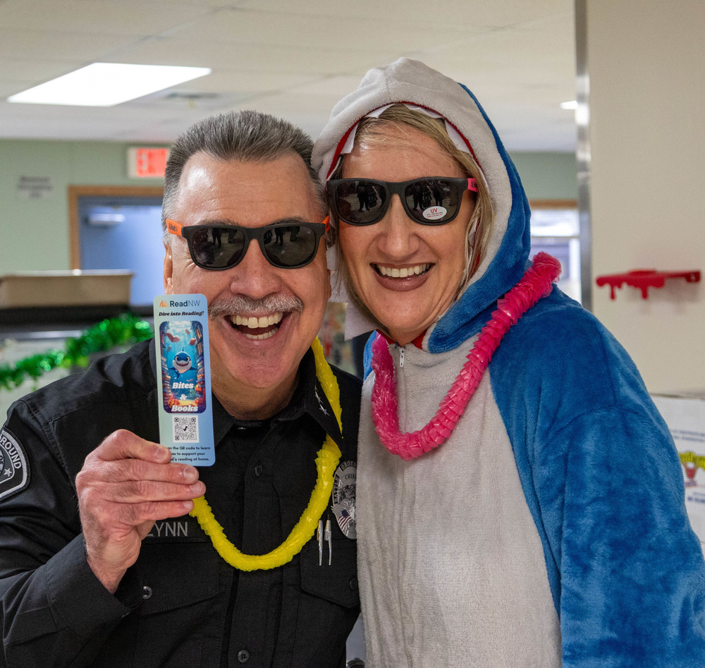 The police chief and a person in a shark costume smile at the camera