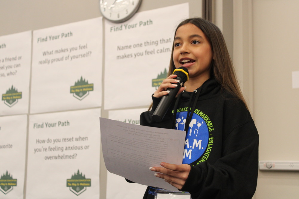 dream team member holding her presentation and speaking into a microphone