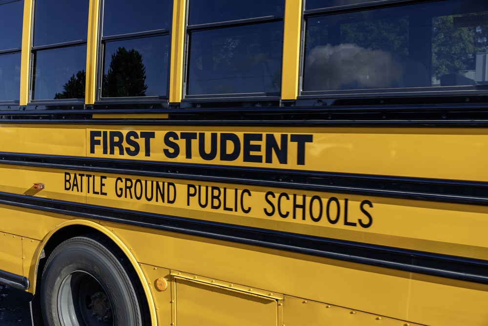 The side of a school bus that reads, "First Student; Battle Ground Public Schools"