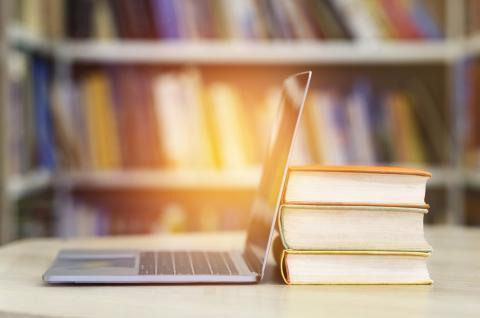 Laptop leaned against a stack of books
