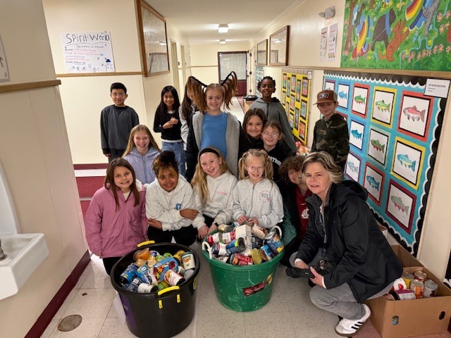 Students pose for a photo with the many food donations that they collected.