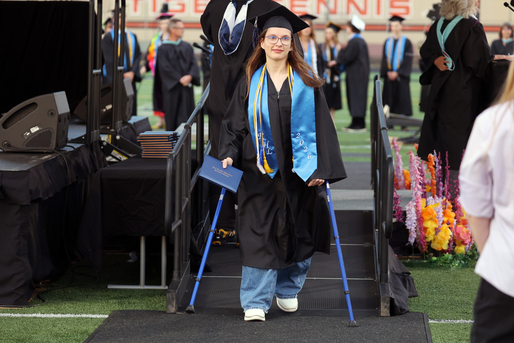 A grad smiles after crossing the stage
