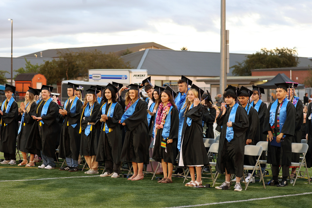 Grads await their chance to move their tassel from one side to another, indicating that they have graduated.