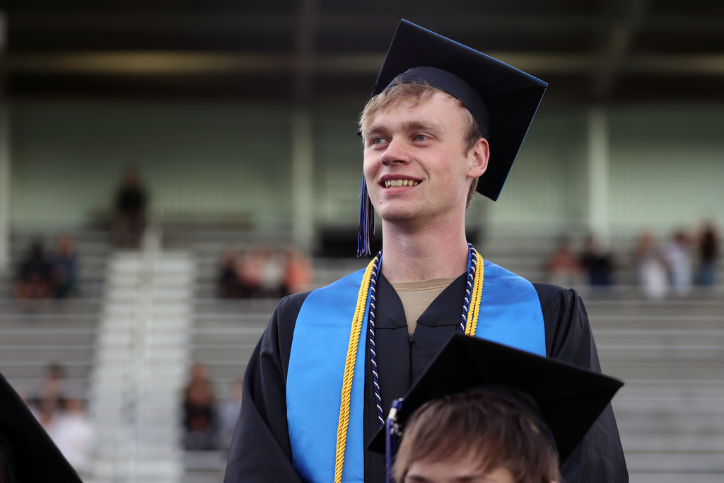 A grad proudly smiles upon receiving recognition