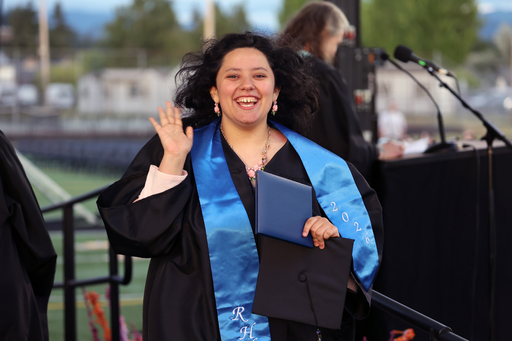 A grad waves after receiving a diploma