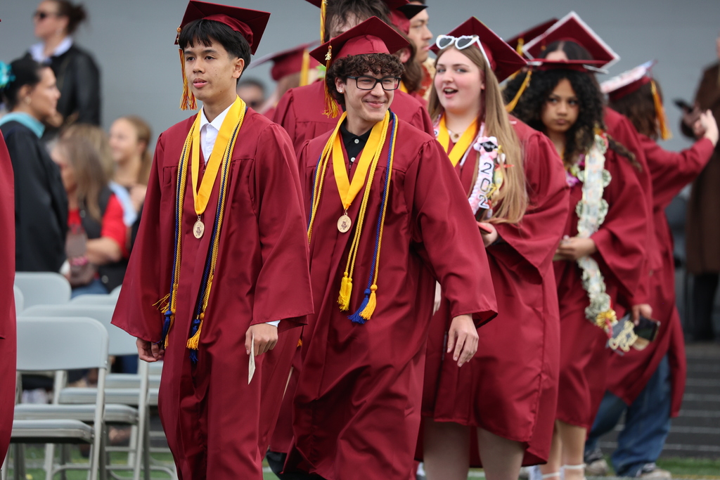 A graduate smiles while entering District Stadium