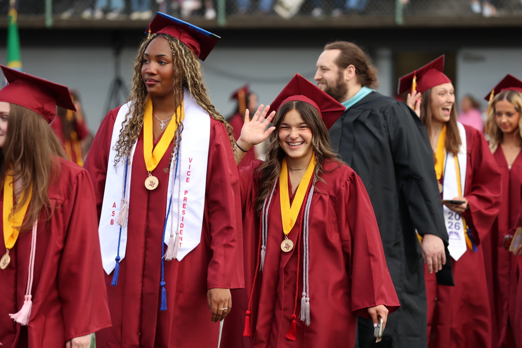 A graduate smiles while entering District Stadium