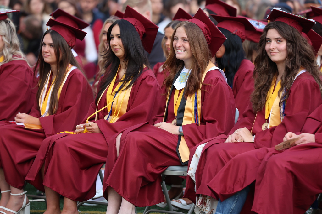 Students smile while listening to a speaker