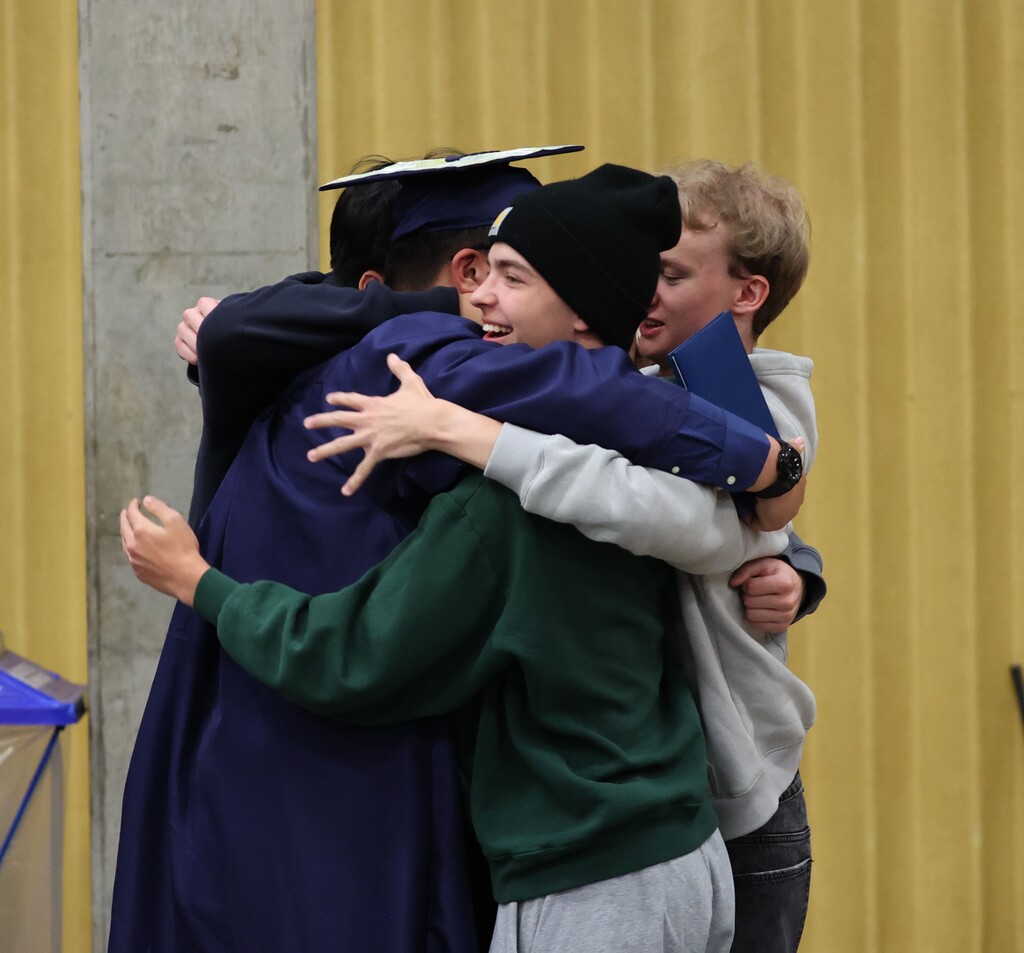 A group of young grads hug