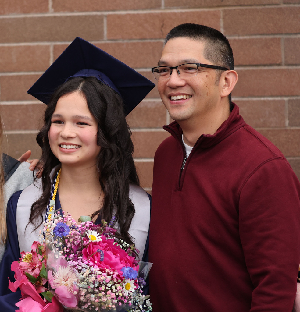 A young dad and his daughter at graduation