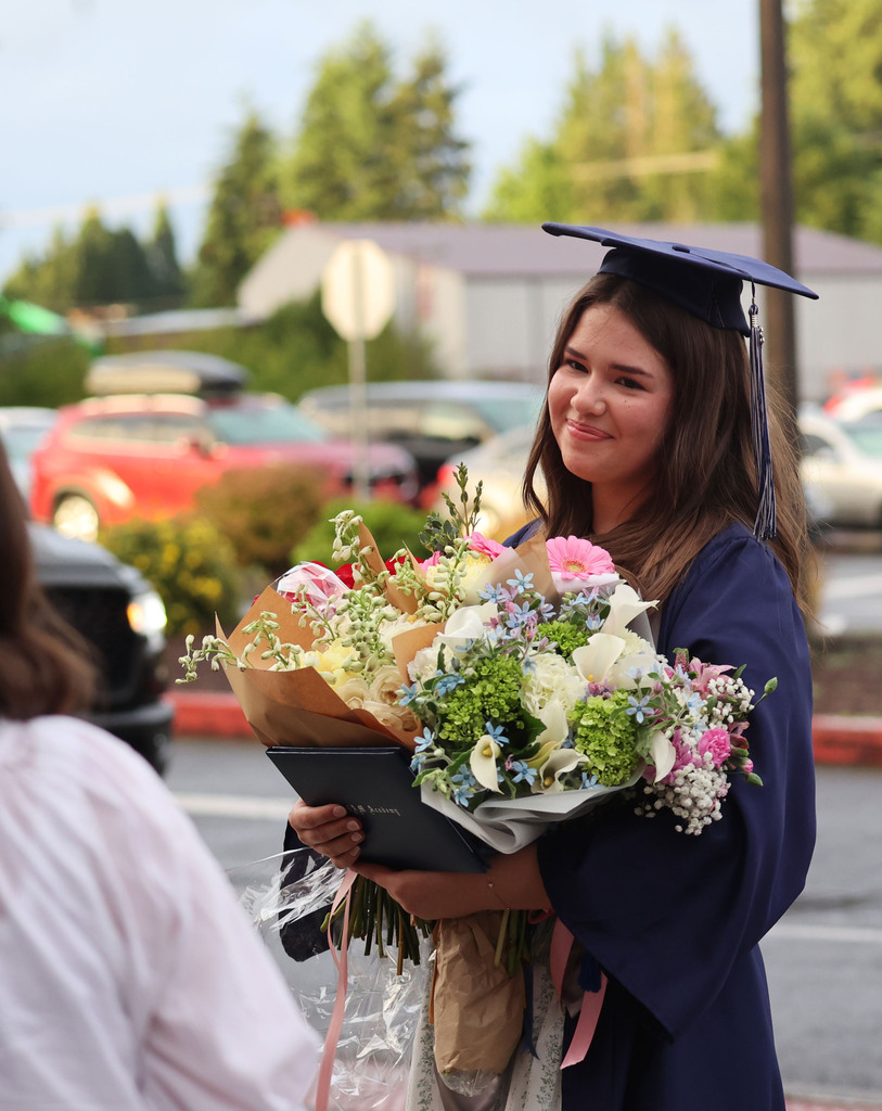 A young woman holds a giant bouquet of flowers