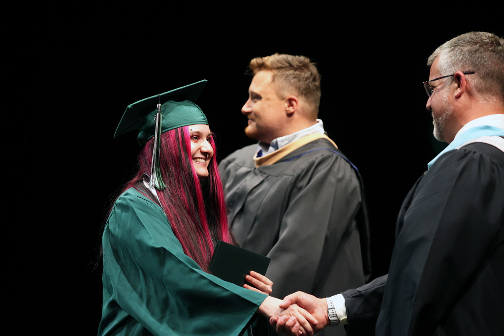 A graduate shakes the principal's hand.