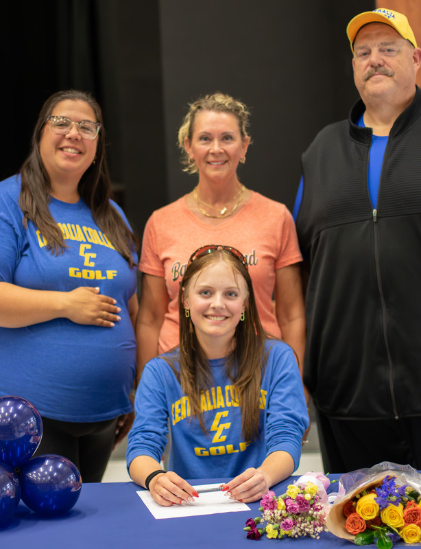 George Fox University coach poses with a student while signing and smiling