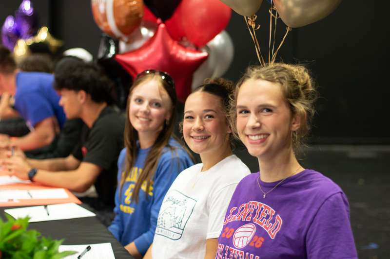 three young senior women smile at the camera