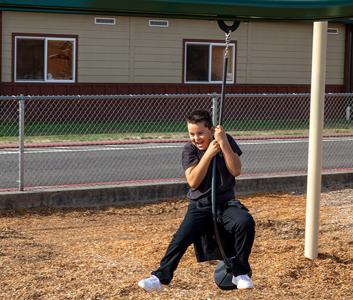 boy playing on playground equipment 