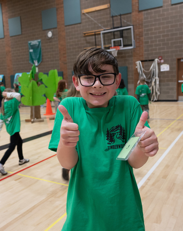 a boy with glasses on giving two thumbs up