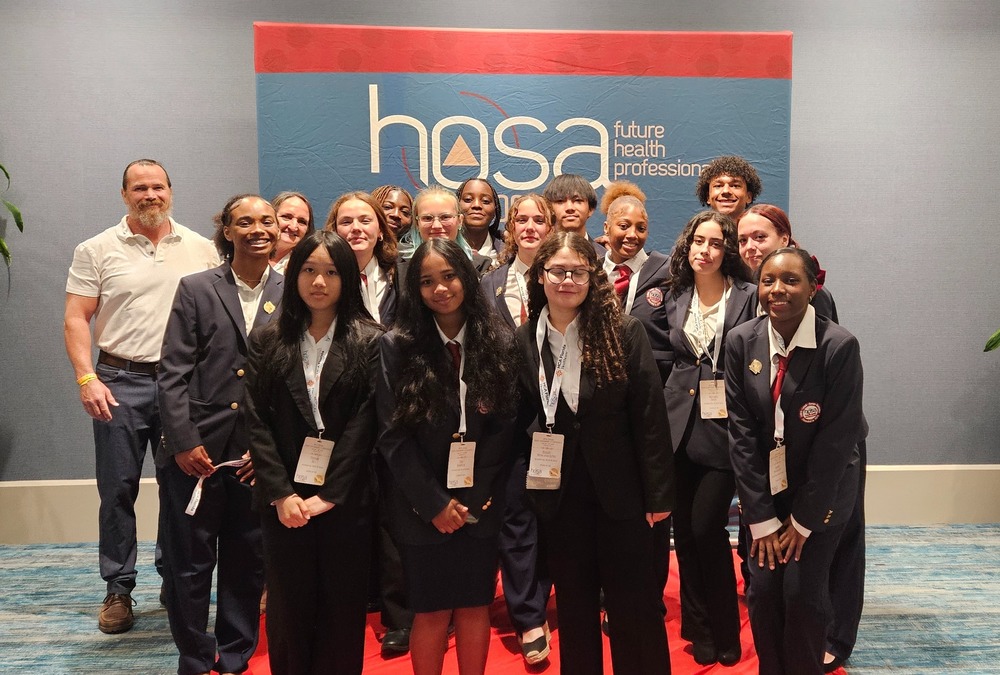 HOSA sponsor Mr. Hennessy, Mrs. Hennessy and  members pose in their uniform blazers