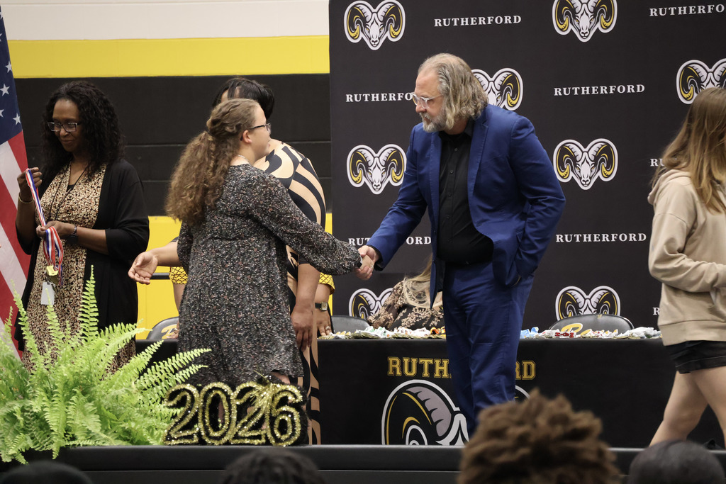 Incoming Principal Jonathan McQuagge shakes a student's hand